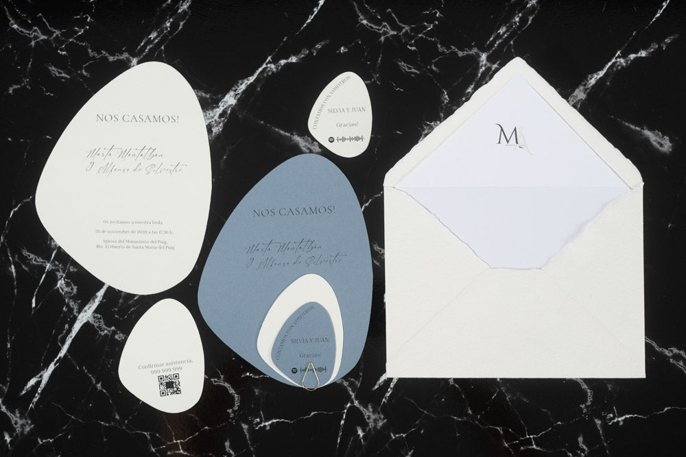 Set completo de invitaciones de boda en formato piedra orgánica color azul, con tarjetas principales, complementarias y sobre artesanal blanco con forro interior.