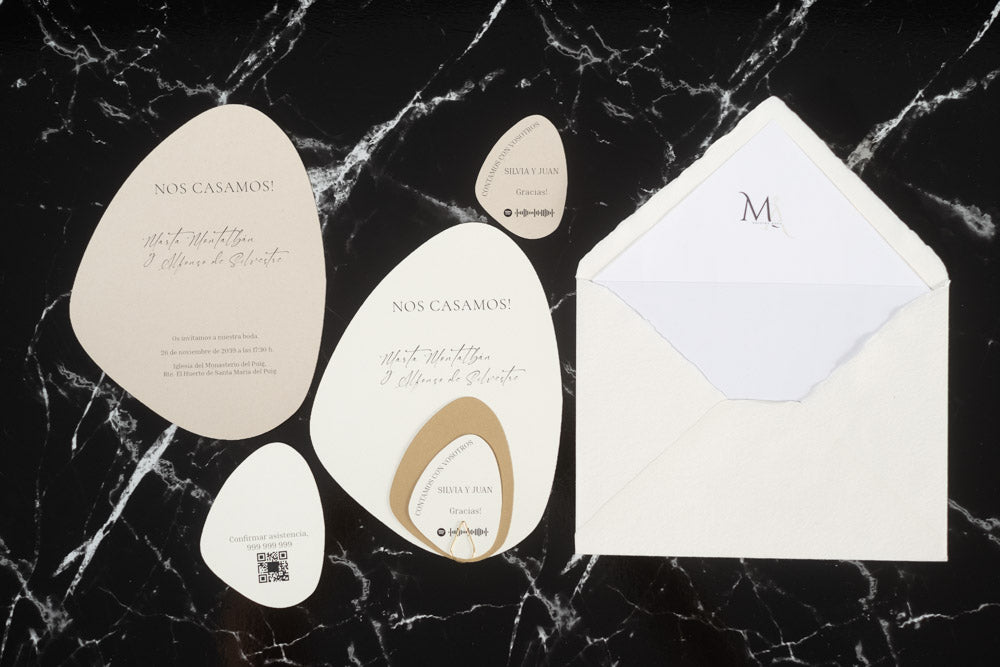 Set completo de invitaciones de boda en formato piedra orgánica color blanco roto, con tarjetas principales, complementarias y sobre artesanal blanco con forro interior.