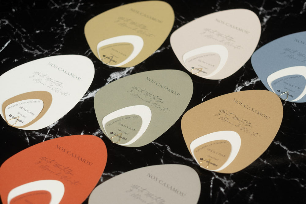 Invitaciones de boda en formato piedra orgánica, diseño moderno disponible en colores terracota, arena, azul, beige, gris y verde.