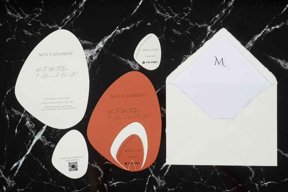 Set completo de invitaciones de boda en formato piedra color terracota, con tarjetas principales, complementarias y sobre artesanal blanco forrado.