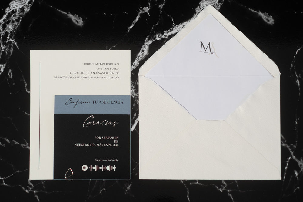 Invitación de boda Anape en azul y negro, acompañada de sobre artesanal blanco con forro interior.