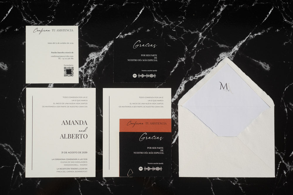 Set completo de la invitación de boda Anape en tonos terracota y negro, con tarjeta principal, tarjetas complementarias y sobre artesanal con forro interior.