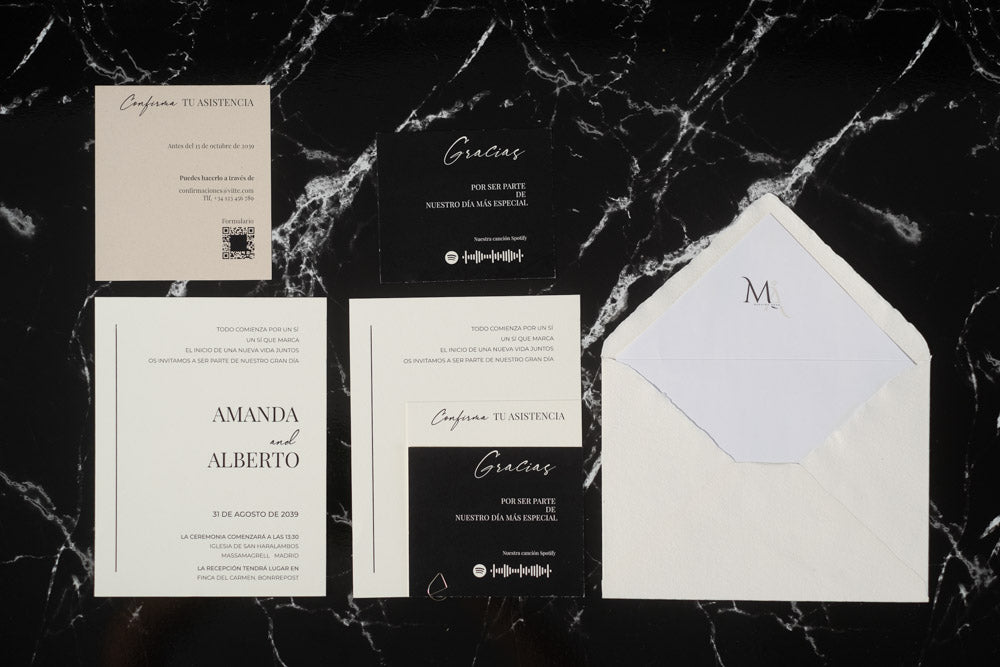 Set completo de la invitación de boda Anape en tonos blanco y negro, con tarjeta principal, tarjetas complementarias y sobre artesanal con forro interior.