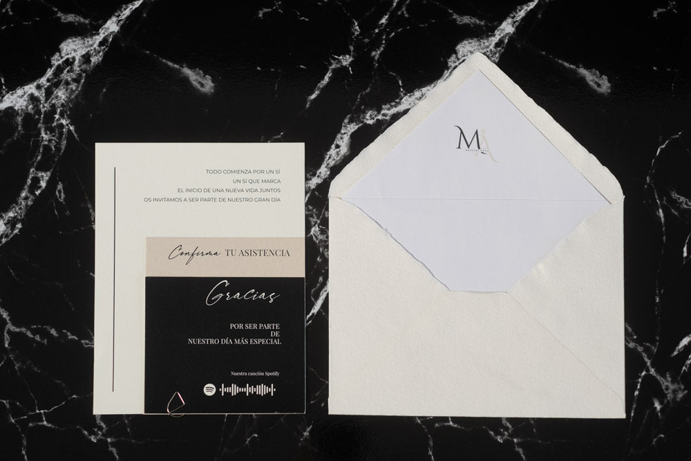 Invitación de boda Anape en beige y negro, acompañada de sobre artesanal blanco con forro interior.