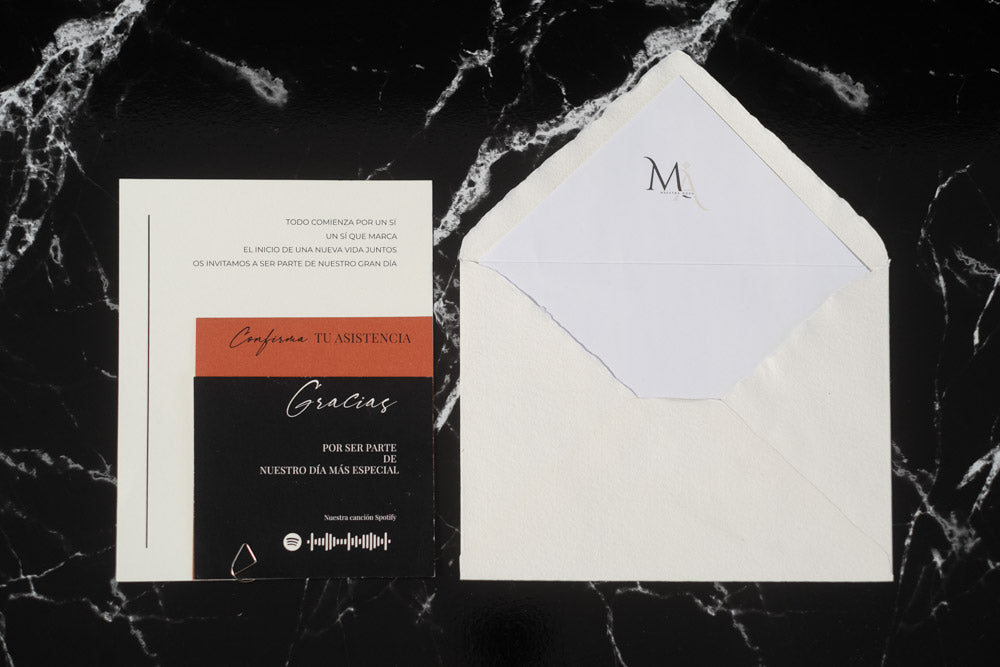 Invitación de boda Anape en terracota y negro, acompañada de sobre artesanal blanco con forro interior.