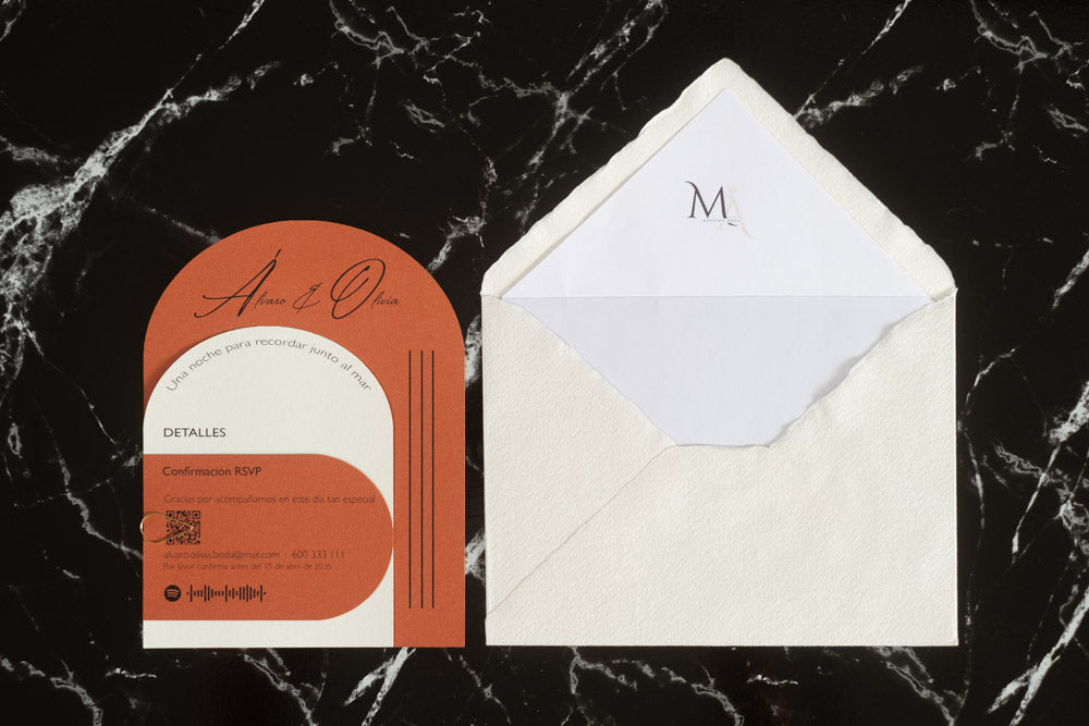 Invitación de boda modelo Aventurina en color terracota con tipografía elegante y detalles en blanco, acompañada de sobre artesanal blanco con forro interior personalizado con iniciales.