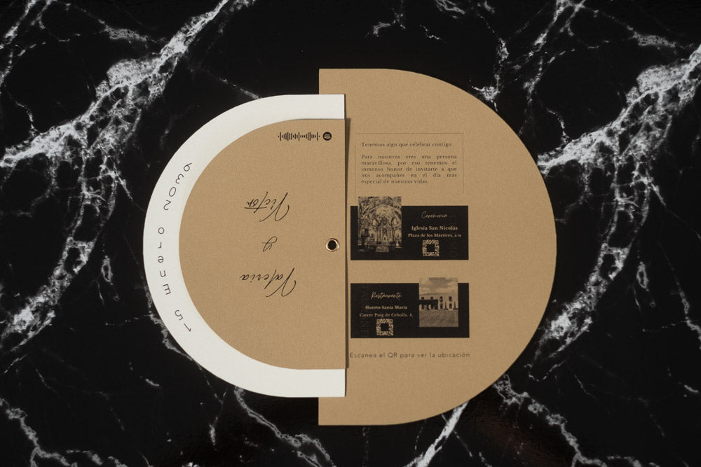 Invitación de boda modelo Cuarzo abierta, mostrando detalles del enlace con fotografías en blanco y negro de la iglesia y el restaurante, junto a códigos QR de ubicación.