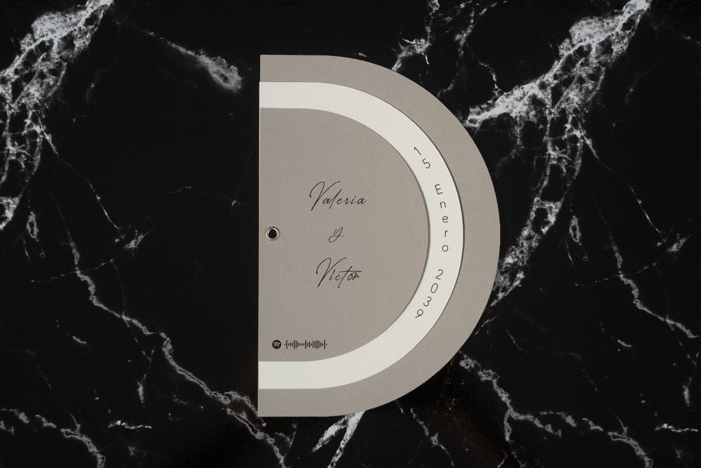 Invitación de boda modelo Cuarzo en color beige, semicircular cerrada, con los nombres de los novios y la fecha del enlace impresa en el borde exterior.