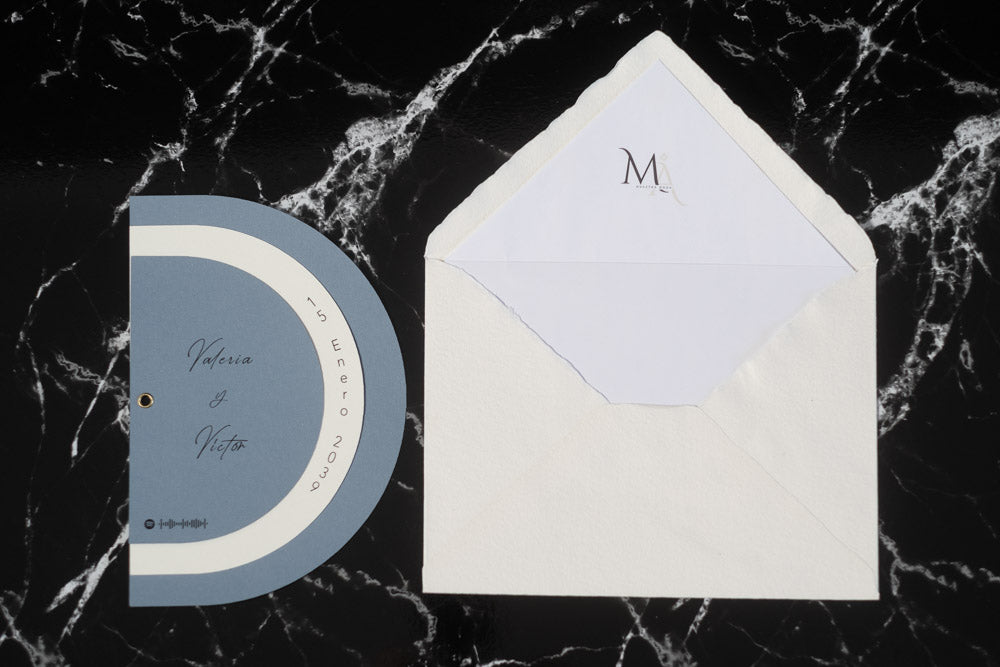 Invitación de boda modelo Cuarzo en color bruma, semicircular cerrada, con los nombres de los novios y la fecha del enlace impresa en el borde exterior. Con Forro blanco incluido.