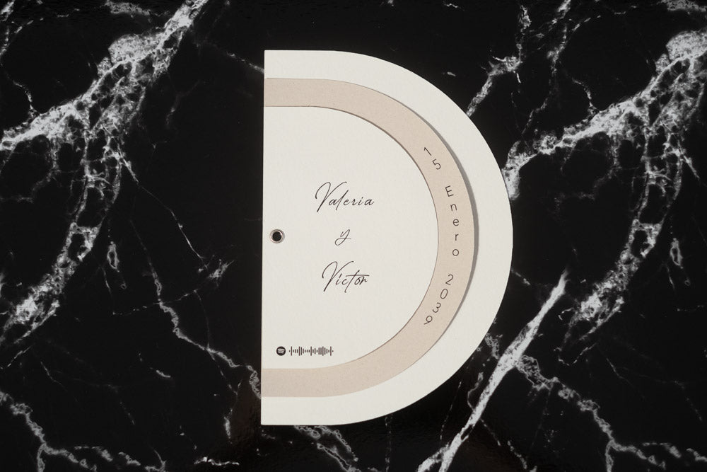 Invitación de boda modelo Cuarzo en color beige, semicircular cerrada, con los nombres de los novios y la fecha del enlace impresa en el borde exterior.