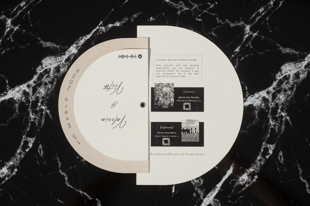 Invitación de boda modelo Cuarzo abierta, mostrando detalles del enlace con fotografías en blanco y negro de la iglesia y el restaurante, junto a códigos QR de ubicación.