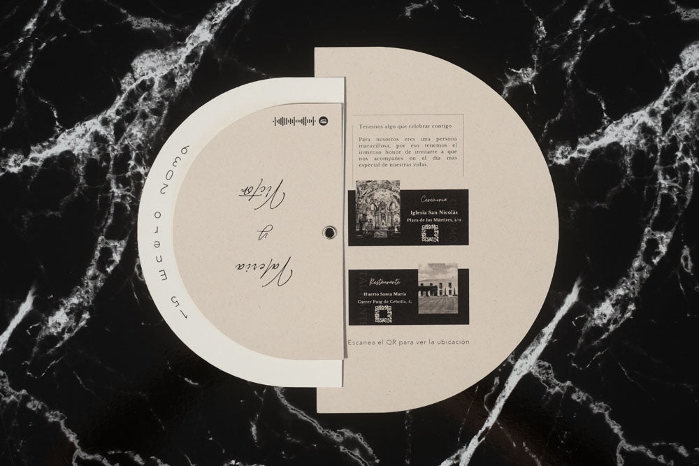 Invitación de boda modelo Cuarzo abierta, mostrando detalles del enlace con fotografías en blanco y negro de la iglesia y el restaurante, junto a códigos QR de ubicación.