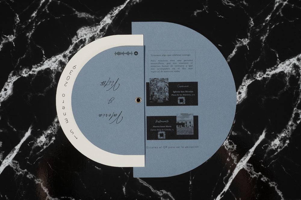 Invitación de boda modelo Cuarzo abierta, mostrando detalles del enlace con fotografías en blanco y negro de la iglesia y el restaurante, junto a códigos QR de ubicación.