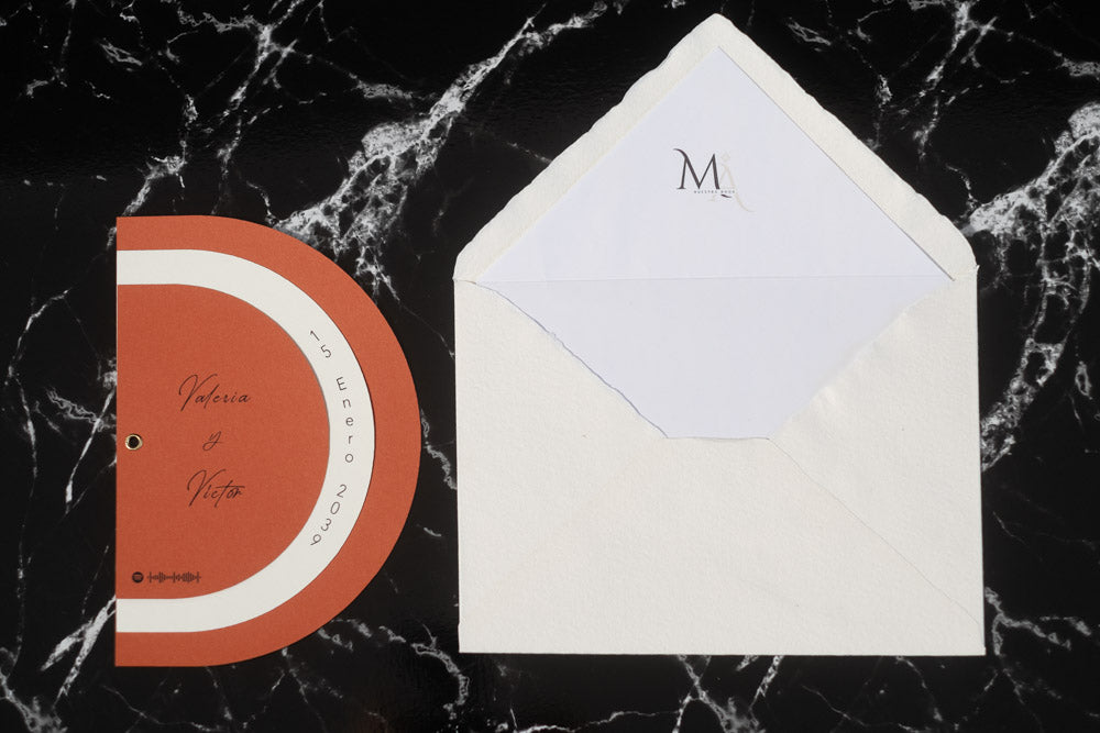Invitación de boda modelo Cuarzo en color terracota semicircular cerrada, con los nombres de los novios y la fecha del enlace impresa en el borde exterior. Con Sobre blanco forrado.