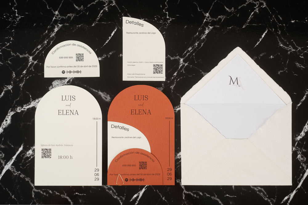 Set completo de la invitación de boda Espinela en color terracota, compuesto por tarjeta principal, tarjetas complementarias y sobre artesanal con forro interior.