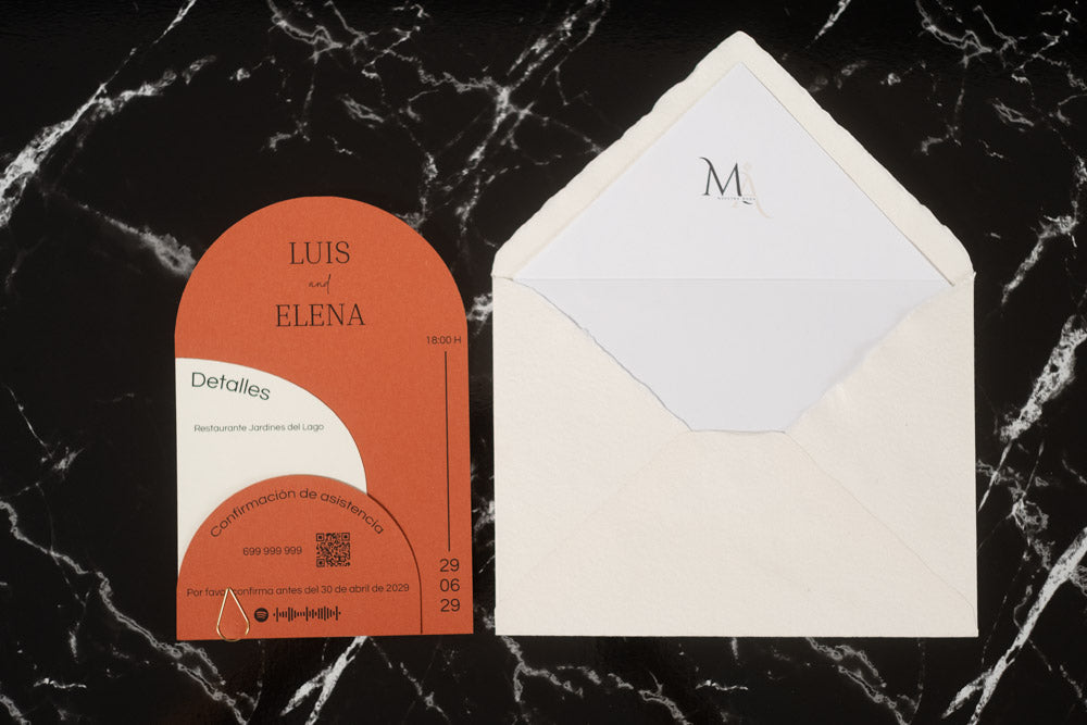 Invitación de boda Espinela en color terracota, con tarjetas semicirculares superpuestas y sobre artesanal hecho a mano con forro interior blanco.