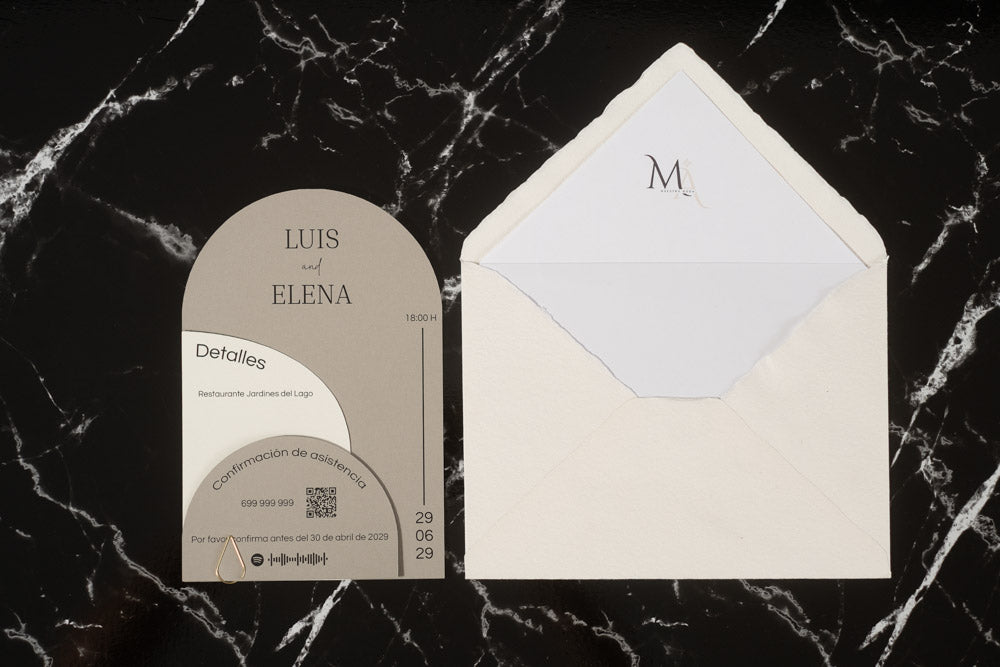 Invitación de boda Espinela en color ceniza, con tarjetas semicirculares superpuestas y sobre artesanal hecho a mano con forro interior blanco.