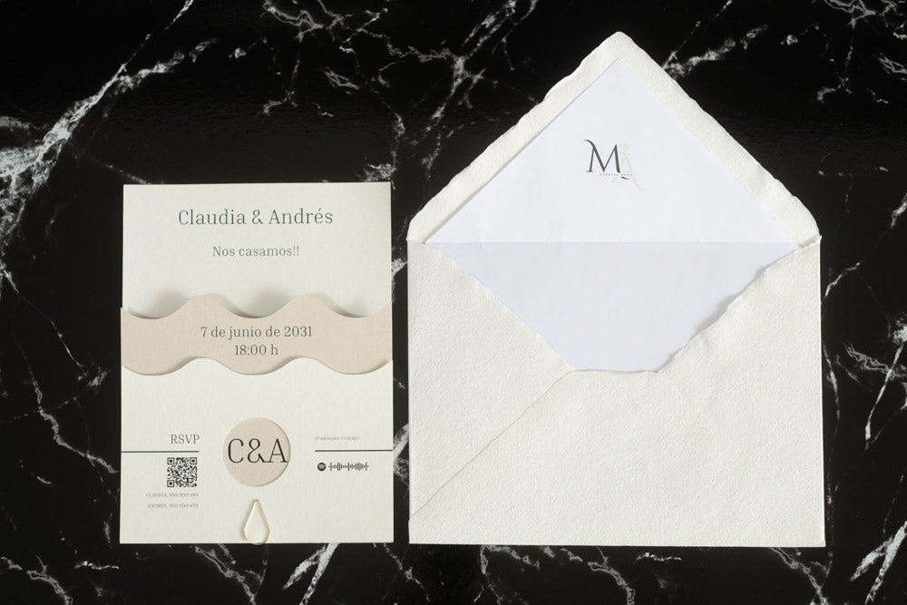 Invitación de boda Jade en color marfil con diseño ondulado y detalles en papel natural, acompañada de sobre artesanal hecho a mano con forro blanco.