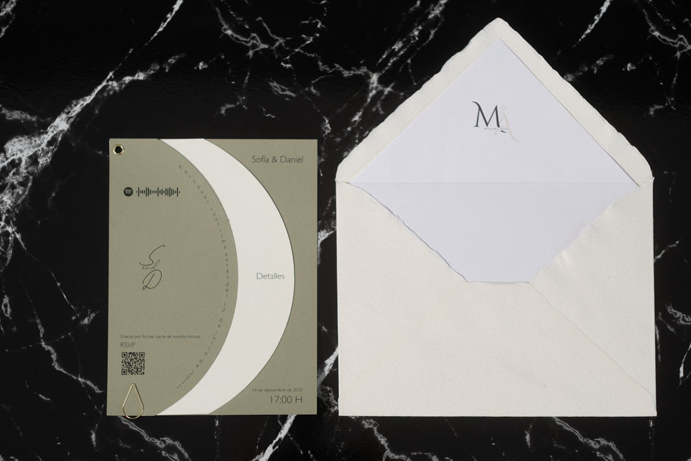 Invitación de boda Larimar color oliva con tarjeta semicircular giratoria y sobre artesanal con forro interior.