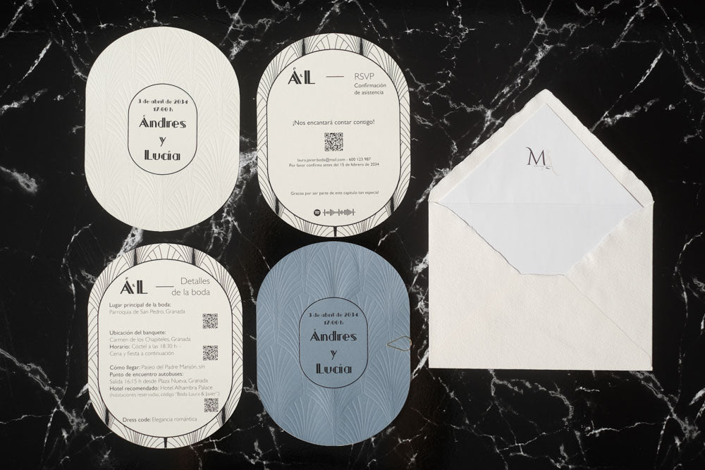 Set completo de invitaciones de boda ovaladas en tonos azul y blanco, con tarjetas de detalles y RSVP, acompañado de sobre artesanal blanco con forro interior.