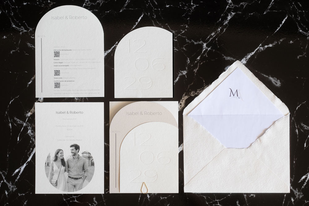 Set completo de invitaciones de boda semicircular en color marfil y blanco, que incluye tarjeta principal, tarjeta de detalles, RSVP y sobre artesanal con forro interior.