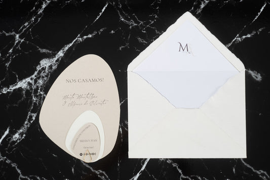 Invitación de boda en formato piedra color beige, acompañada de sobre artesanal blanco forrado en su interior.