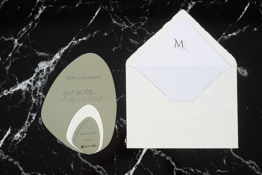 Invitación de boda modelo orgánico en tonos verdes con sobre artesanal blanco forrado en su interior, diseño elegante y original en formato piedra.