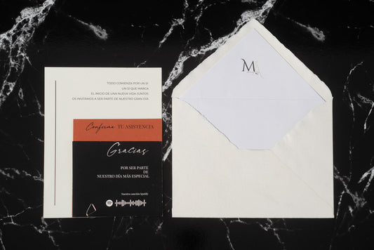 Invitación de boda Anape en terracota y negro, acompañada de sobre artesanal blanco con forro interior.