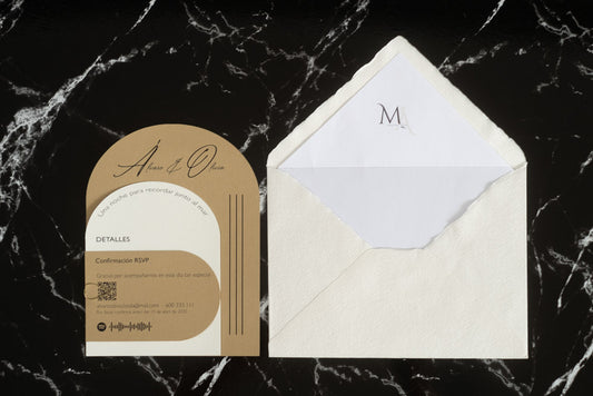 Invitación de boda Aventurina en color arena, diseño semicircular con tipografía elegante, presentada junto a sobre artesanal blanco con forro interior a juego.