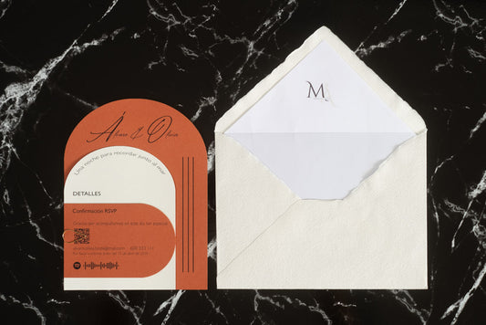 Invitación de boda modelo Aventurina en color terracota con tipografía elegante y detalles en blanco, acompañada de sobre artesanal blanco con forro interior personalizado con iniciales.