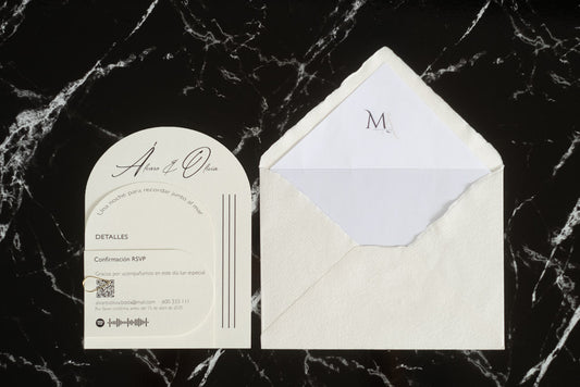 Invitación de boda Aventurina en color nieve, diseño semicircular con detalles modernos y tipografía elegante, presentada junto a sobre artesanal blanco con forro interior a juego.