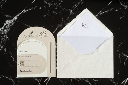 Invitación de boda Aventurina en color marfil, diseño semicircular con detalles modernos y tipografía elegante, presentada junto a sobre artesanal blanco con forro interior a juego.