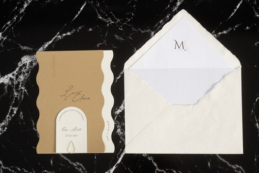 Invitación de boda Berilio en color nieve con bordes ondulados, acompañada de sobre artesanal hecho a mano con forro interior blanco.