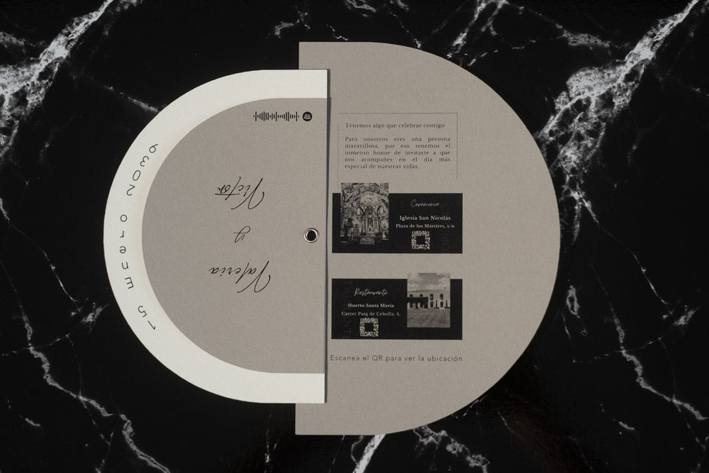 Invitación de boda modelo Cuarzo abierta, mostrando detalles del enlace con fotografías en blanco y negro de la iglesia y el restaurante, junto a códigos QR de ubicación.