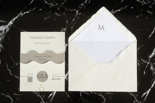 Invitación de boda Jade en color gris ceniza con diseño ondulado en papel natural de alta calidad, acompañada de sobre artesanal con forro blanco.