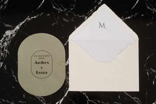 Invitación de boda ovalada en tono verde oliva con textura grabada y tipografía negra, acompañada de sobre artesanal blanco con forro interior personalizado.
