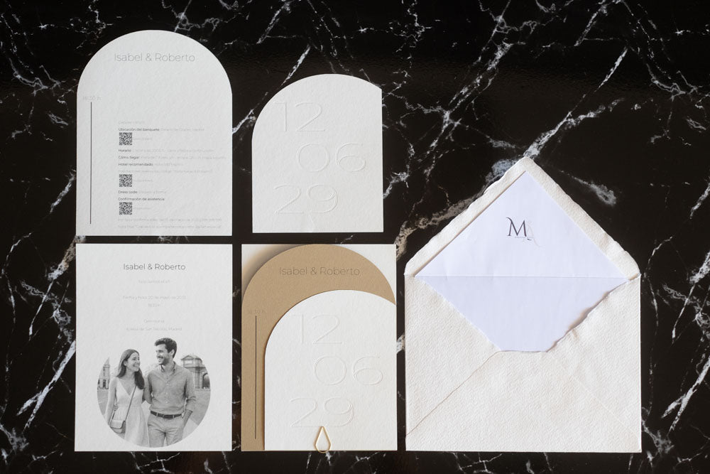 Set completo de invitaciones de boda semicircular en color arena y blanco, que incluye tarjeta principal, tarjeta de detalles, RSVP y sobre artesanal con forro interior.